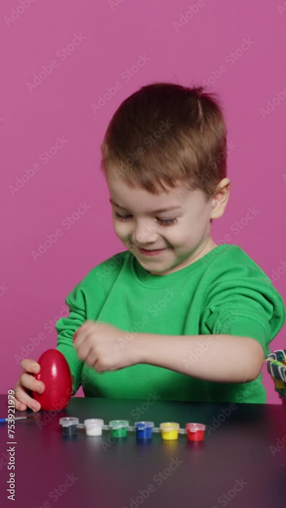 Vertical Video Young toddler focusing on decorating easter eggs with stamps and watercolor paint, preparing handcrafted ornaments for spring holiday festivity. Small cute boy coloring decorations Vertical Video Young toddler focusing on decorating easter eggs with stamps and watercolor paint, preparing handcrafted ornaments for spring holiday festivity. Small cute boy coloring decorations