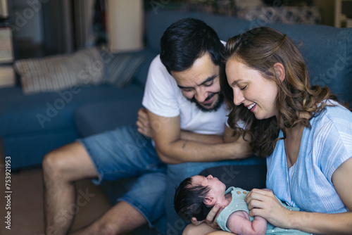 Parents lovingly caressing their newborn baby at home