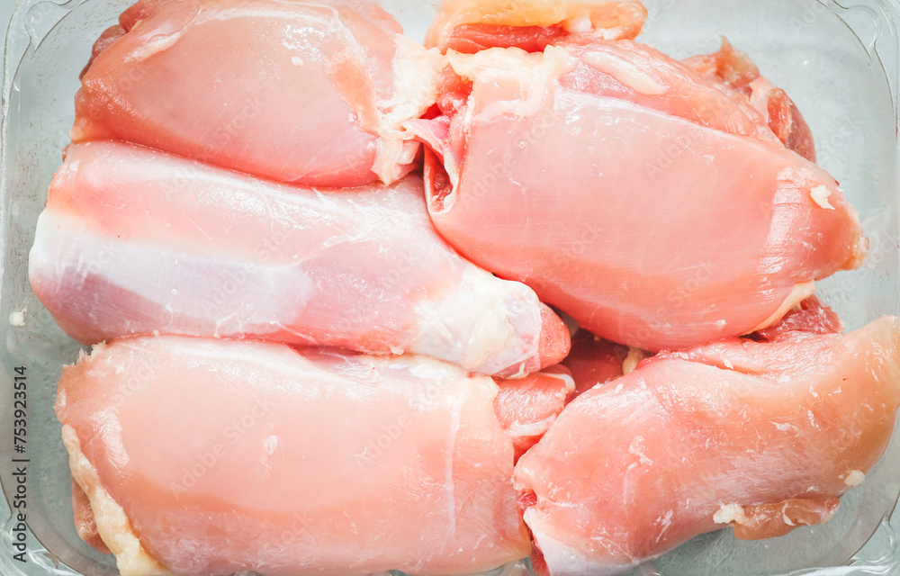 Raw boneless chicken thighs lie in a transparent plastic package Raw boneless chicken thighs lie in a transparent plastic package