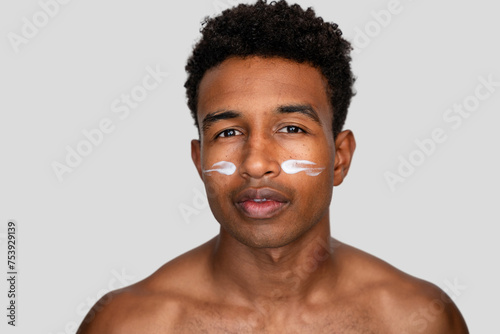 Man with moisturizer cream on face. photo