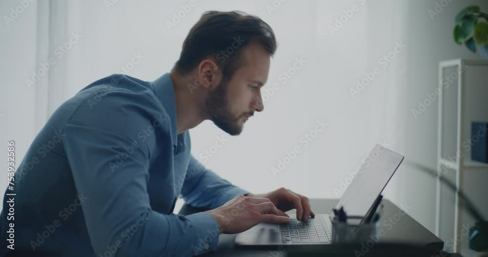 Young businessman using laptop sitting at desk Young businessman using laptop sitting at desk