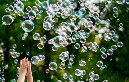 children's hands catching soap bubbles photo