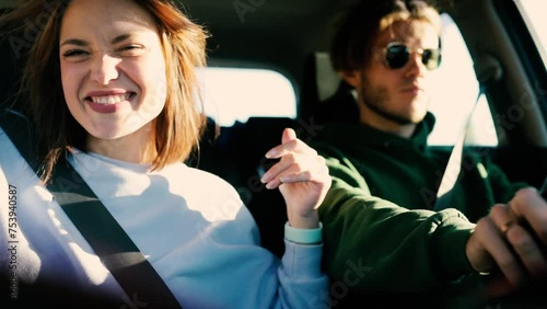 loving couple is driving in a car on a sunny day and having fun, traveling by car.
