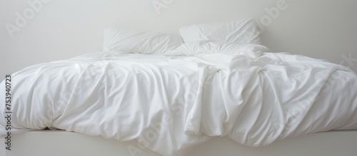 A three feet white bed with a white comforter and pillows neatly arranged on top. The bed is in immaculate condition, suggesting it was just vacated after waking up in the morning.