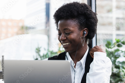 Content black woman enjoying music in earphones in cafe photo