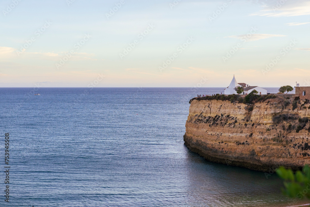 Algarve, Portugal. View of the sea and cliff with Chapel of Our Lady of the Rock (Igreja de Nossa Senhora da Rocha). Dreamy sunset scenery. Porches, Algarve, Portugal Algarve, Portugal. View of the sea and cliff with Chapel of Our Lady of the Rock (Igreja de Nossa Senhora da Rocha). Dreamy sunset scenery. Porches, Algarve, Portugal
