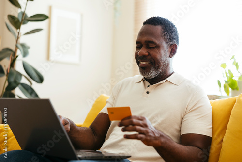 Middle age man doing some online shopping with credit card photo