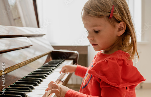 crop of little girl hand learning to play the piano photo