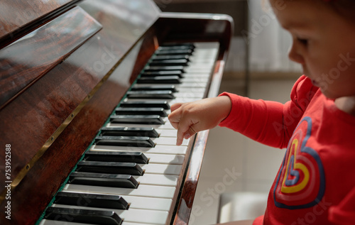 crop of little girl hand learning to play the piano photo