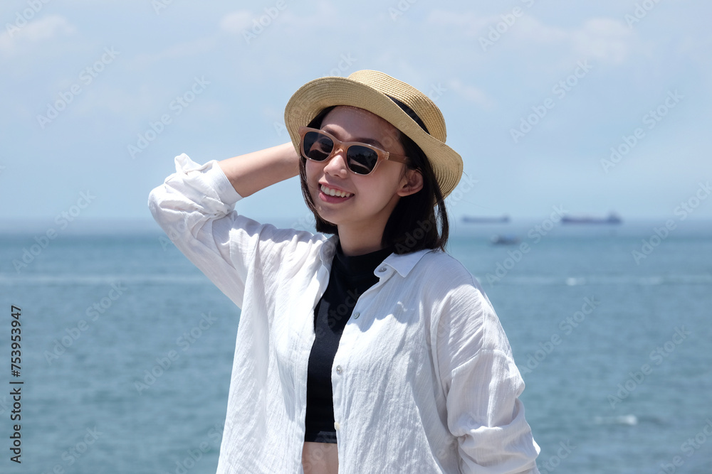 Smiling asian girl in front of the sea Smiling asian girl in front of the sea