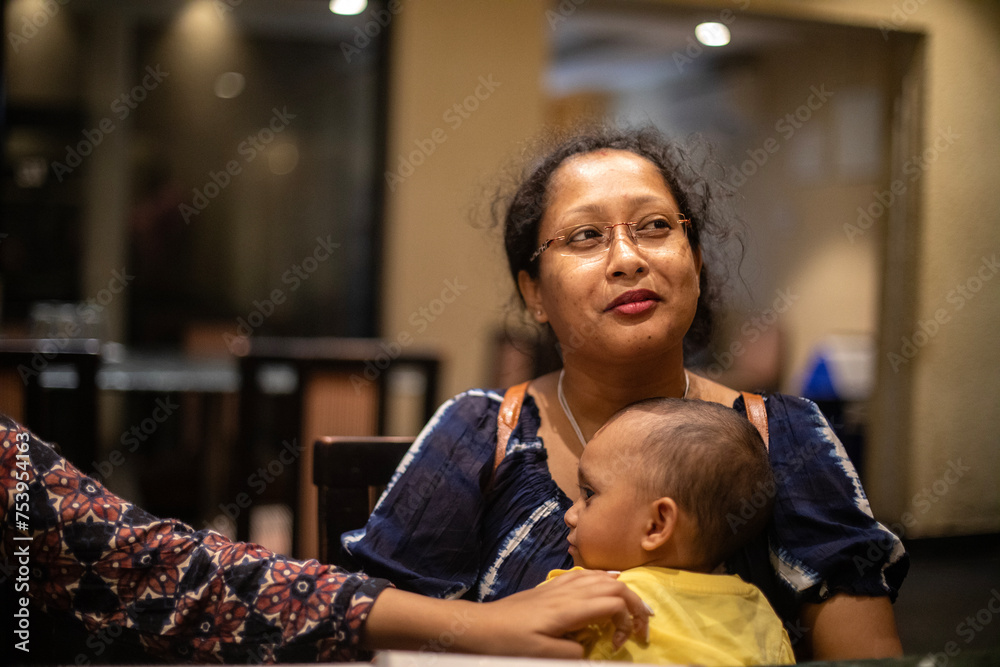 Happy Indian family making interaction inside a restaurant Happy Indian family making interaction inside a restaurant