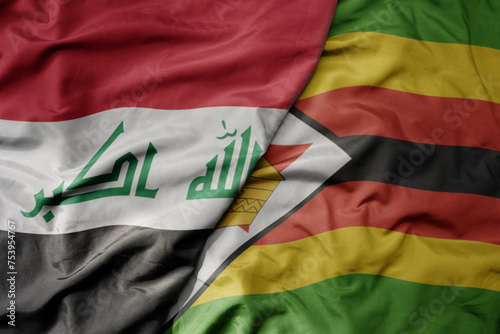 big waving national colorful flag of zimbabwe and national flag of iraq.