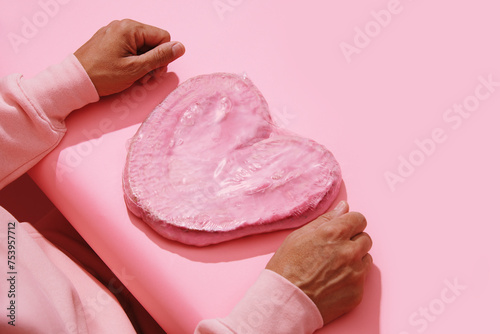 man in pink with a pink heart-shaped pastry photo