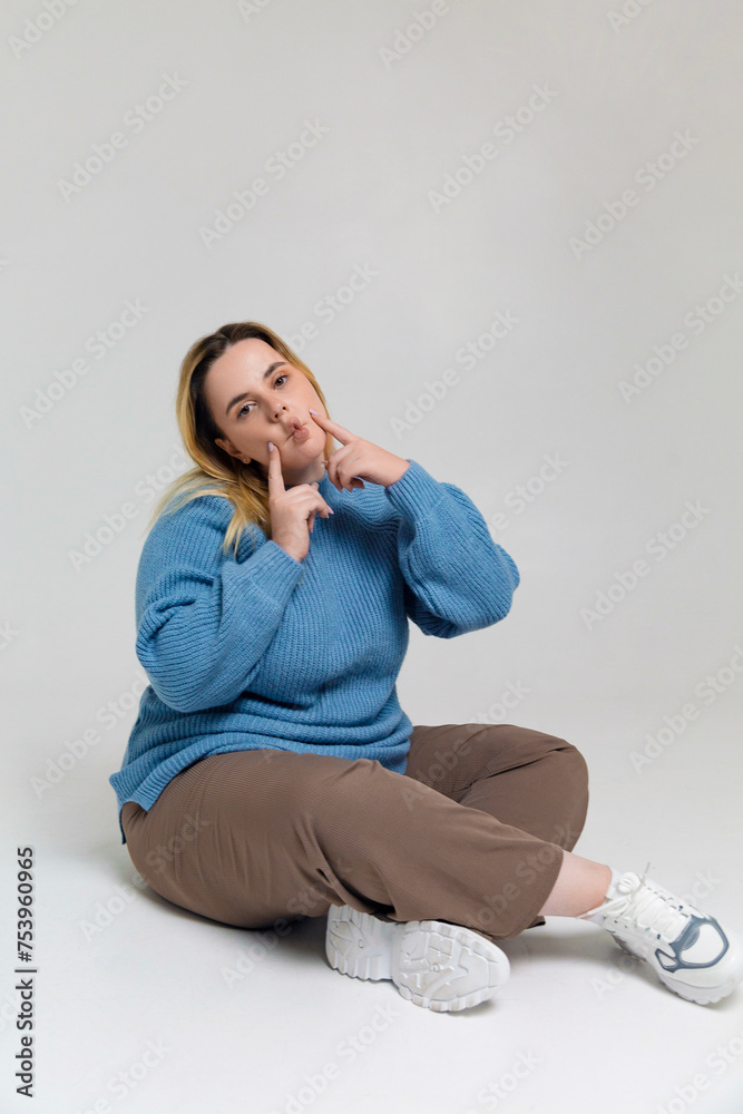Funny young plus size woman sitting on floor in room Funny young plus size woman sitting on floor in room