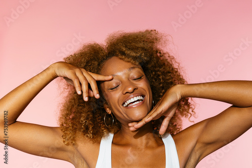 Cheerful woman with curly hair smiling in studio photo