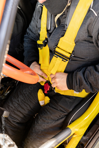 Rally driver fastening seat belt. photo