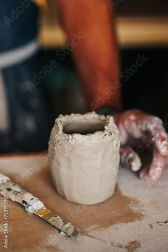 Freshly modeled clay vase with the rim filled with slips of clay photo