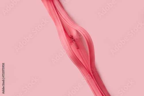 Two pink open zippers depicting abstract shape of female vagina photo