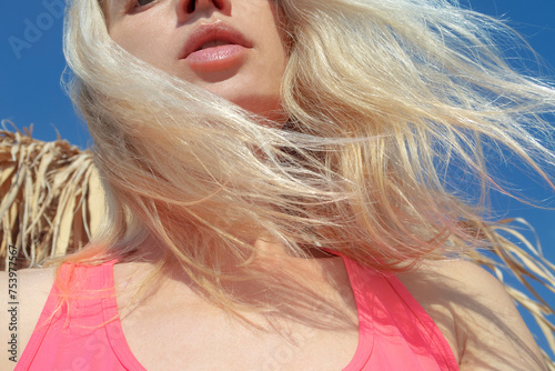 Natural lips and blond hair in the wind and blue sky photo