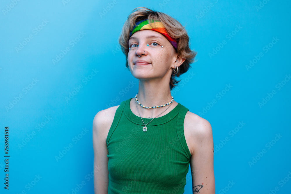 Stylish queer woman in colorful outfit looking at camera in studio Stylish queer woman in colorful outfit looking at camera in studio