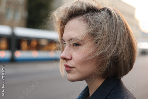 Melancholic blond model looking ahead on the street, city scenario photo