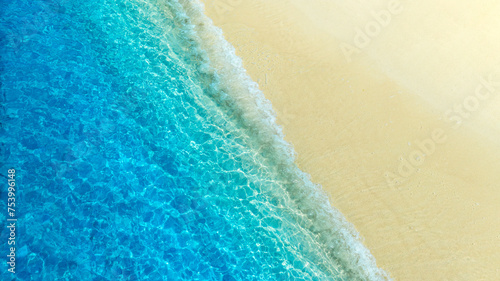 Top view of sandy beach for summer vacation concept. Nature of the beach and sea in summer with sunlight, and light sand. The sea sparkles against the blue sky. Sandy Beach for summer vacationconcept