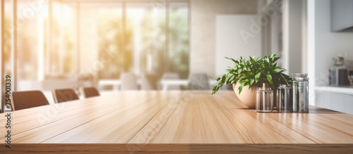 A wooden table in a clean, modern interior design setting, with a potted plant placed on top of it. The table is part of a contemporary kitchen island setup, featuring wooden dining chairs,