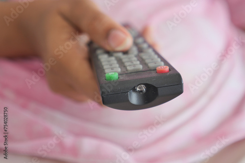 close up of women hand holding tv remote.