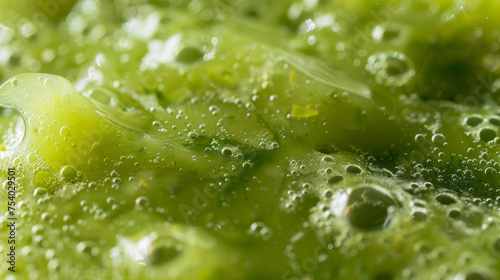 A closeup of a bright green algaebased smoothie with small bubbles visible on the surface. The drink appears thick and creamy with flecks of additional nutrients and superfoods photo