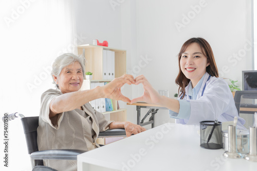 asian female doctor and old patient show heart sign with hand together, happiness and relationship in hospital, they feeling happy and smile, happiness hospital