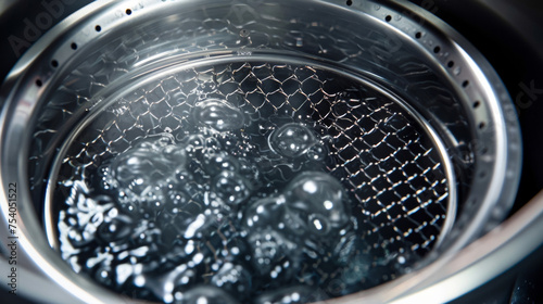 A detailed shot of the oil filter mesh inside the deep fryer capturing any debris to maintain the oils freshness.