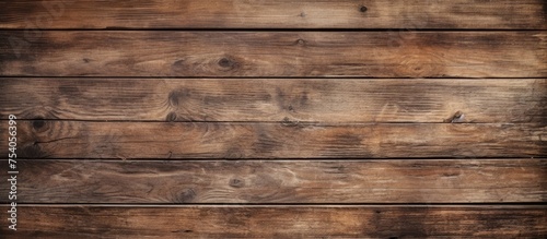 A weathered wooden wall with a dark brown background, showcasing rustic texture and aged character. The wood is worn and washed out, adding a sense of history and charm to the overall appearance.