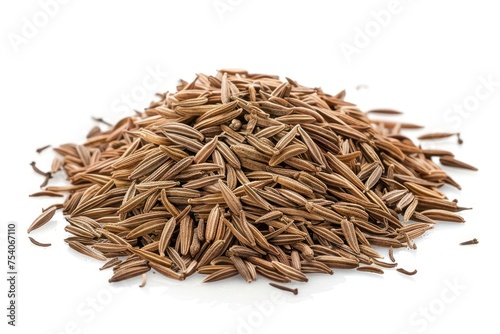 A pile of cumin on a white background. The seeds are brown and scattered. Concept of abundance and natural beauty