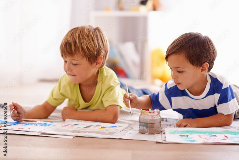 Young children, painting and creative with paint brush on floor or playing room, hobby and drawing together at home. Brothers, motor skills and growth for childhood development with smile for artwork Young children, painting and creative with paint brush on floor or playing room, hobby and drawing together at home. Brothers, motor skills and growth for childhood development with smile for artwork