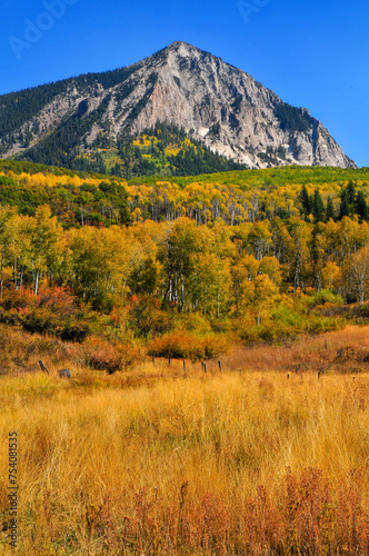 Rugged Marcellina Mountain surrounded by fall colors and yellow grass as seen from the Kebler Pass mountain road, on the way to Crested Butte, Colorado, USA. photo
