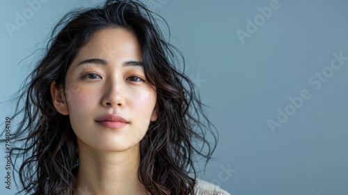 Beauty portrait of a natural young Japanese woman with a soft grey copy space background