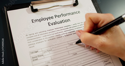 Close-up Of A Person Filling Performance Evaluation Form