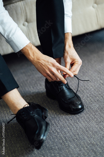 Man ties his black shoes. Close-up view