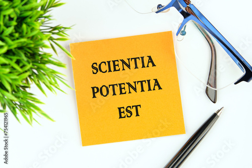 the phrase Scientia Potentia Est (Knowledge is power) written in Latin on an orange sticker on a white background photo