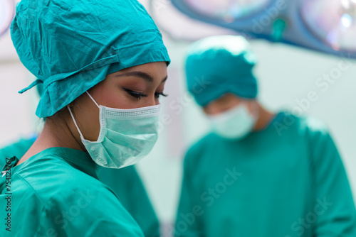 Focused surgeons performing surgery in operating room. Group of surgeons doing surgery in hospital operating theater.