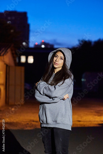 A girl in gray clothes is standing in a doorway. An abandoned industrial building. The time of day is twilight. © Fotoproff