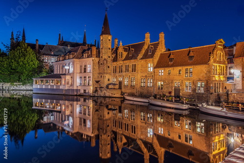 Illuminated houses on the canal in Bruges in the evening. Rosary Quay in the center of the old town of the Hanseatic city at blue hour. historical merchants' houses with reflections