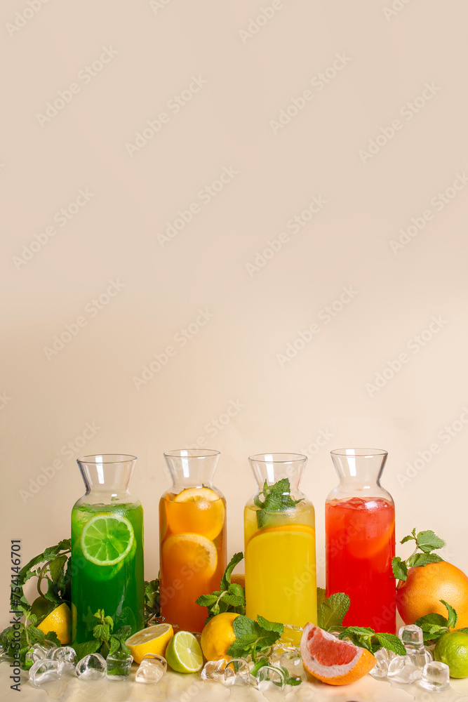 Assorted cold lemonades in glass jugs on an ochre background. photos for the menu Assorted cold lemonades in glass jugs on an ochre background. photos for the menu