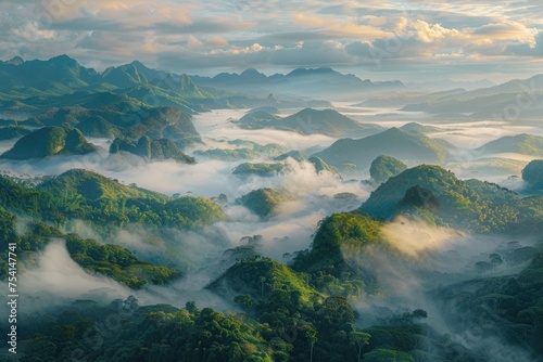 An aerial view of a foggy tropical valley at sunrise, with the tips of the mountains peeking through the sea of clouds. 
