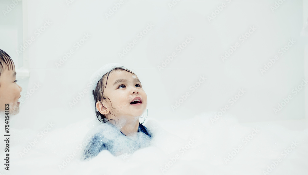 Cute little girl taking bath playing with foam and soap bubbles. Hygiene for infant and baby. Soft focus. Copy space. Cute little girl taking bath playing with foam and soap bubbles. Hygiene for infant and baby. Soft focus. Copy space.