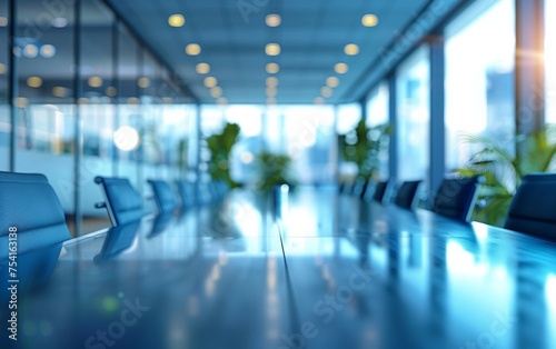 Conference in modern glass-walled boardroom with indistinct figures in background. © tonstock