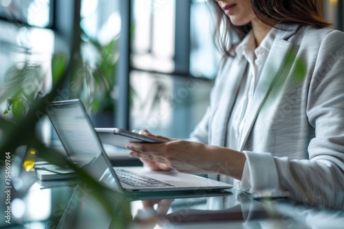 Business professional working with a tablet and laptop.