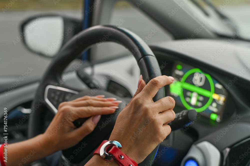 a woman is driving a car. women's hands on the steering wheel.