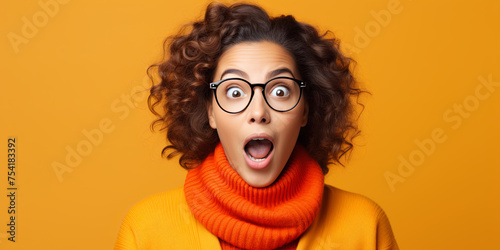  Close-up photo of shackled surprised young woman in glasses isolated on orange background with copy space. Enjoy reading black friday sale banner © Анна Ілющенко