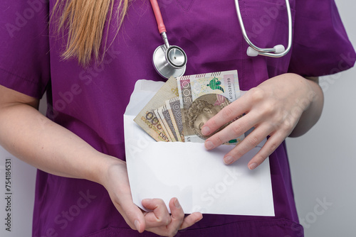 Pani doktor trzyma w dłoniach kopertę z pieniędzmi 